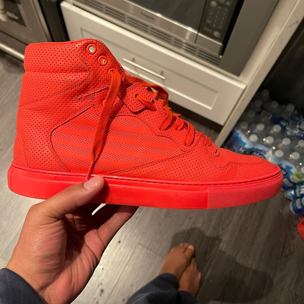 Red Balenciaga high top sneakers.